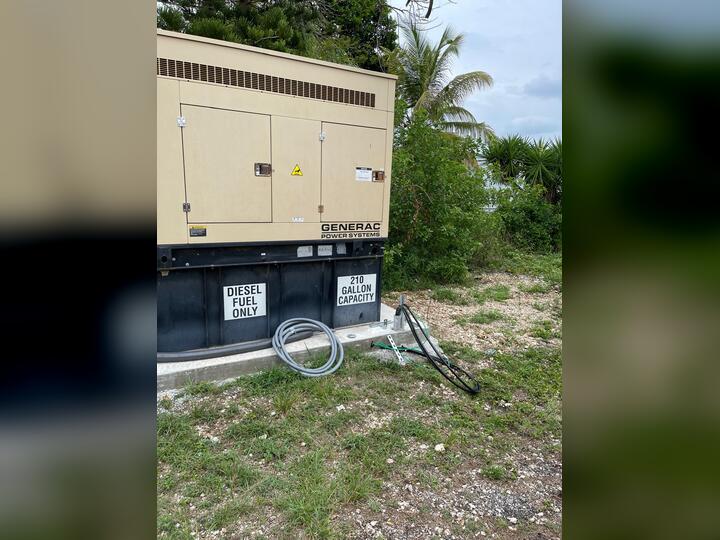 Electrician installing a commercial standby generator and automatic transfer switch in Miami